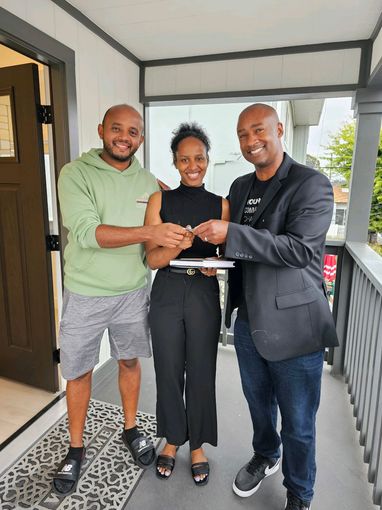 Clients of Eloise Real Estate Group and Ryan Porter of Eloise Real Estate Group are standing on a porch holding keys.