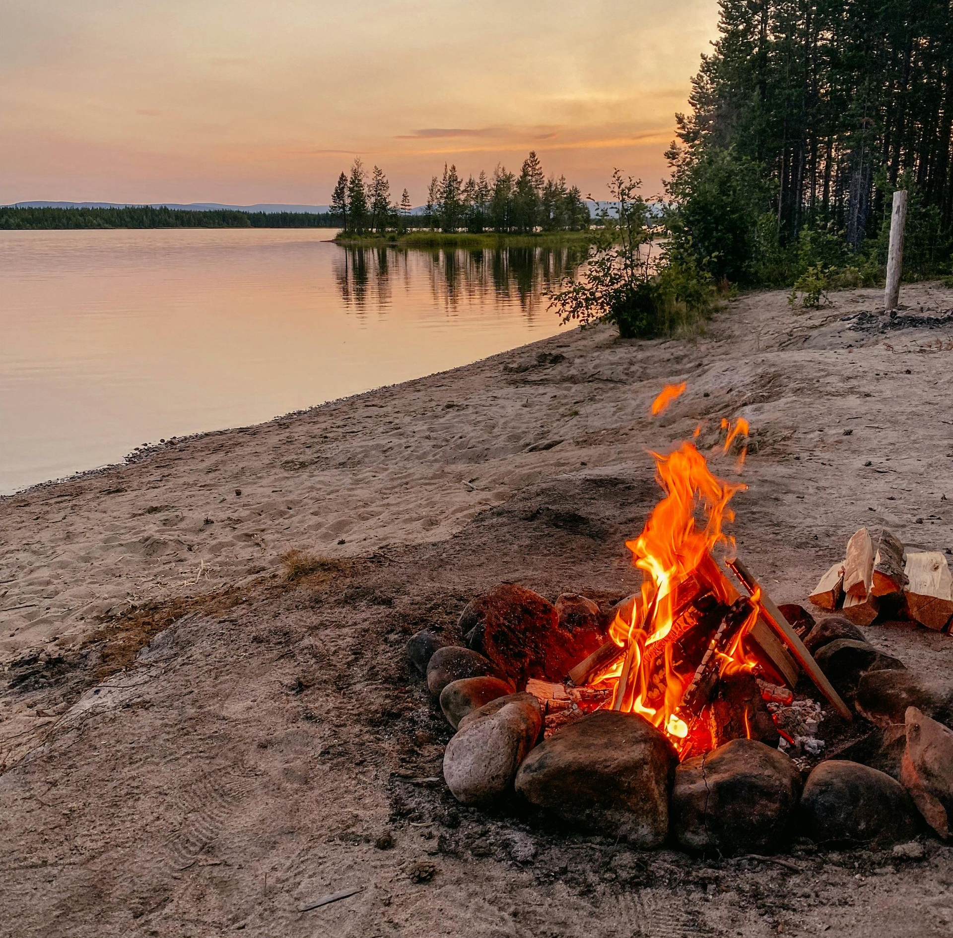 Meer, strandje, kampvuur en bos.