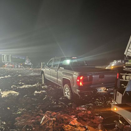 A truck is parked in a rocky area at night.