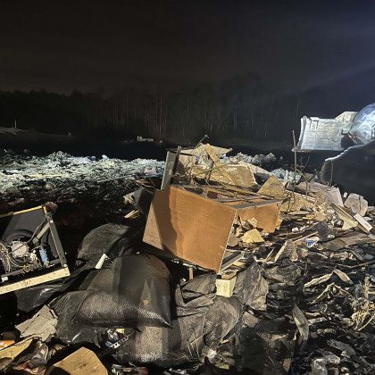 A pile of trash is sitting in the middle of a field at night.
