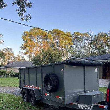 A dumpster trailer is parked in front of a house.
