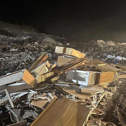 A pile of wood is sitting on top of a pile of trash.