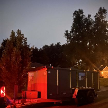 A trailer is parked on the side of the road at night.