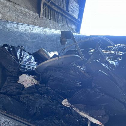 A pile of garbage is sitting in the back of a truck.