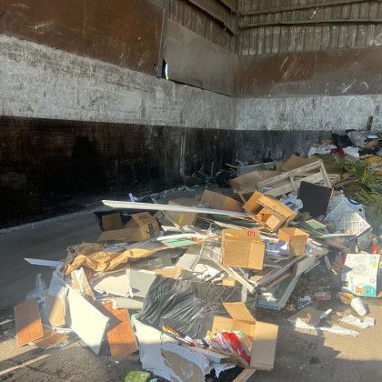 A pile of trash is sitting in the back of a truck.