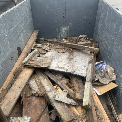 A dumpster filled with wood and cardboard.