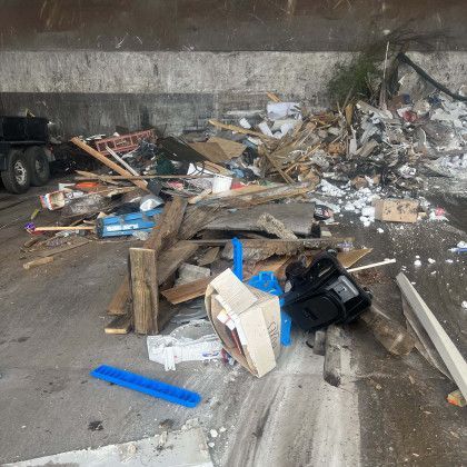 A pile of trash is sitting on the side of the road.