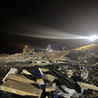 A pile of garbage in a dumpster at night