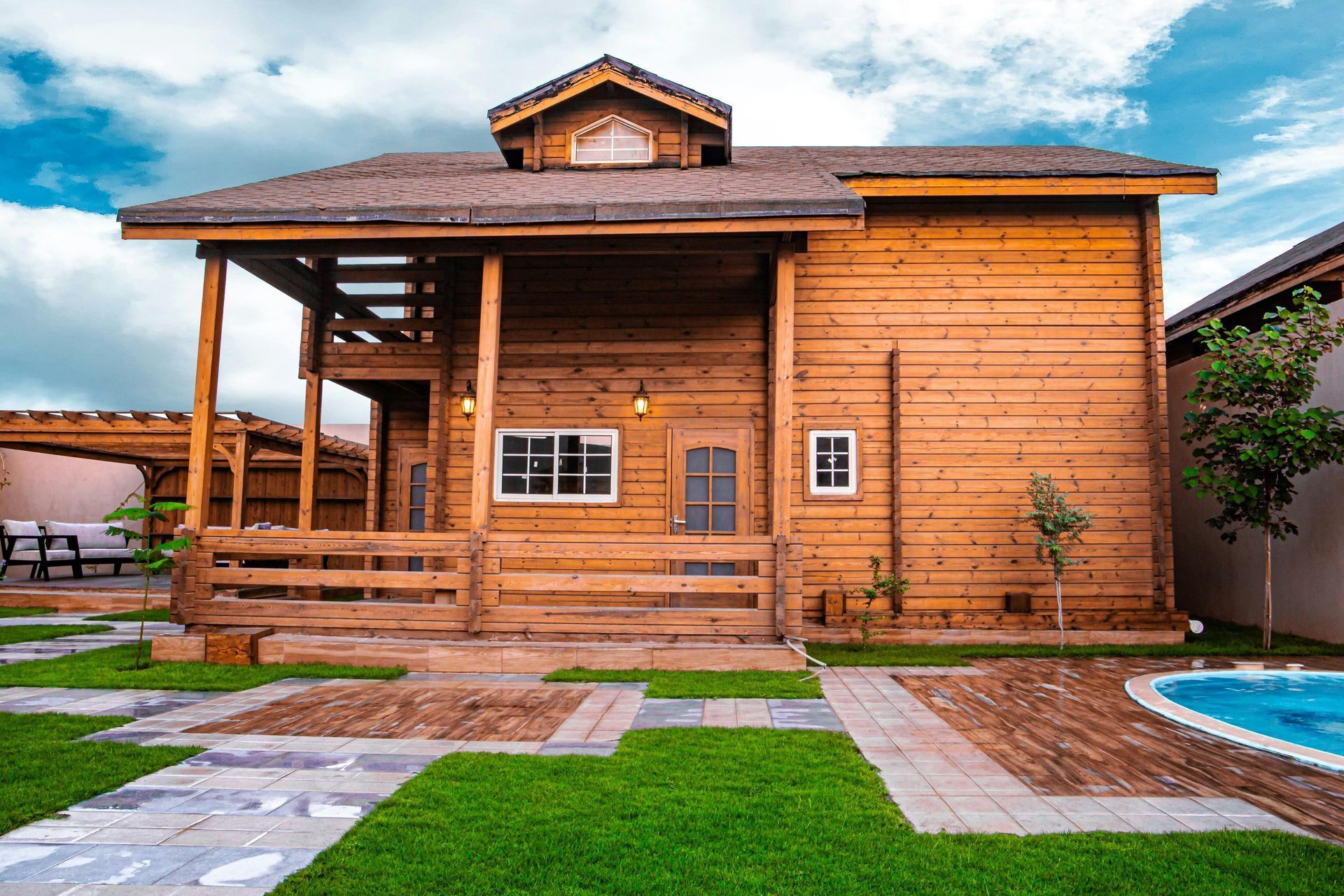 A large wooden house with a swimming pool in the backyard.