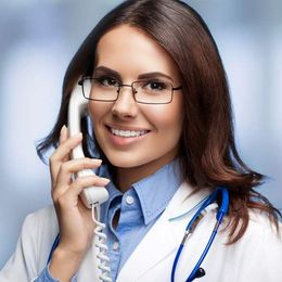 A female doctor is smiling while talking on a phone Contact Victory Medical Institute for a Consultation