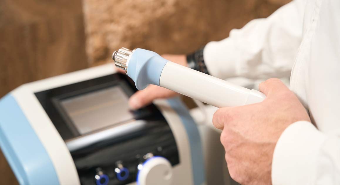A close-up of a doctor holding a medical machine in their hands for Sexual Dysfunction Treatments NJ and NYC by Victory Medical Institute