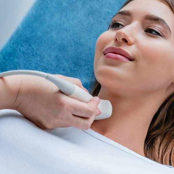 A woman with Hypothyroidism is getting an ultrasound of her neck.