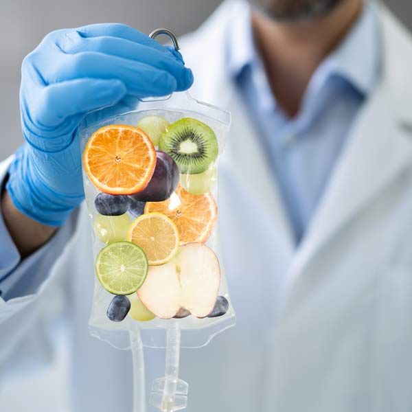 A doctor is holding an IV Infusions bag of fruit to symbolize health and wellness