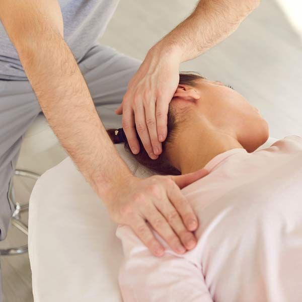 A man is treating a woman with Osteopathic Manipulative Medicine