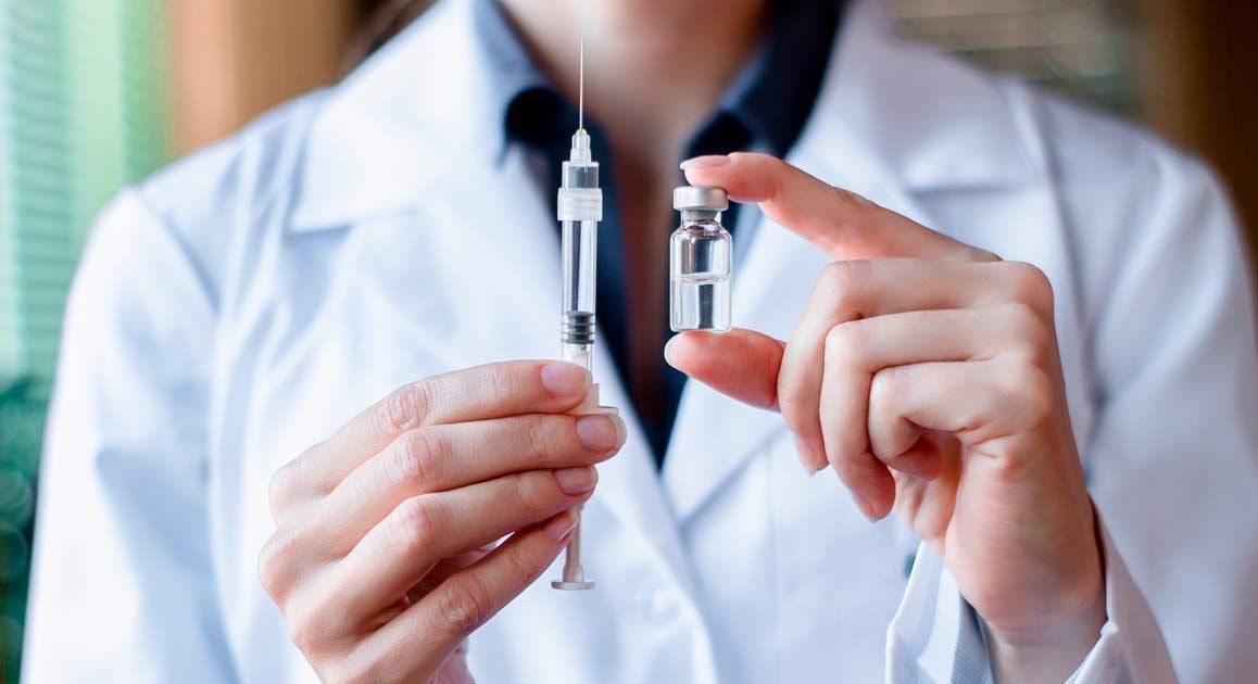 A female doctor is holding two syringes in her hands for Peptide Therapy NJ and NYC at Victory Medical Institute
