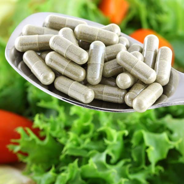 A spoon filled with pills representing Guided Weight Loss Supplementation
