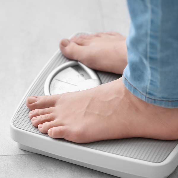 A person is standing on a scale with their feet on it. Take the First Step Toward Success Contact Victory Medical Institute for a Consultation