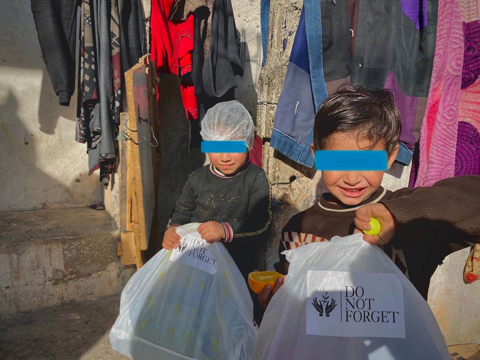 Two boys from Nahr El Bared Refugee camp holding a donation from Do not forget Organization.