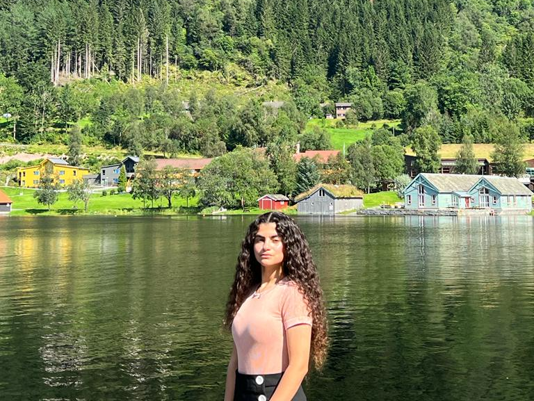 A picture of Sarah Abu Karsh standing behind a fjord