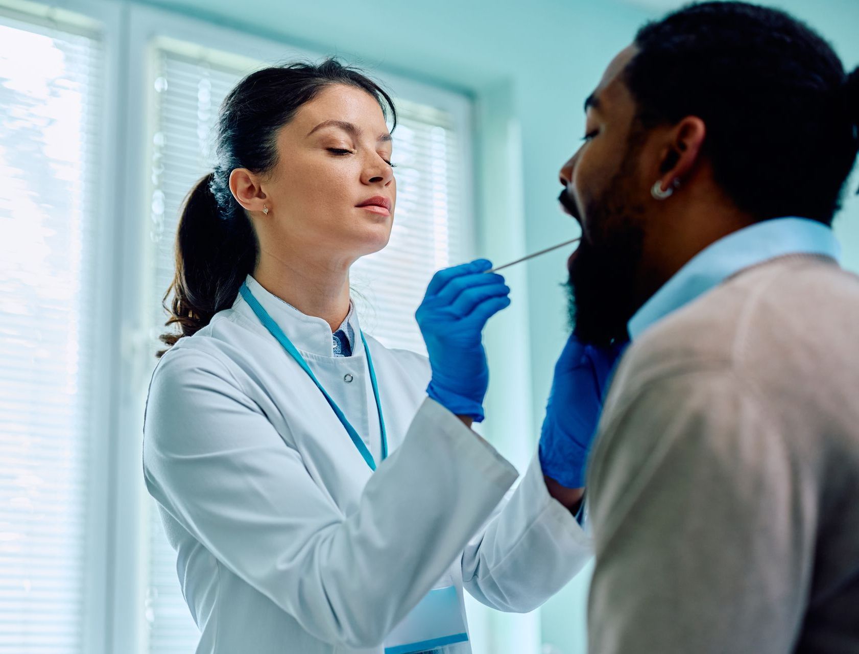 Doctor uses a throat swab to conduct a healthcare test
