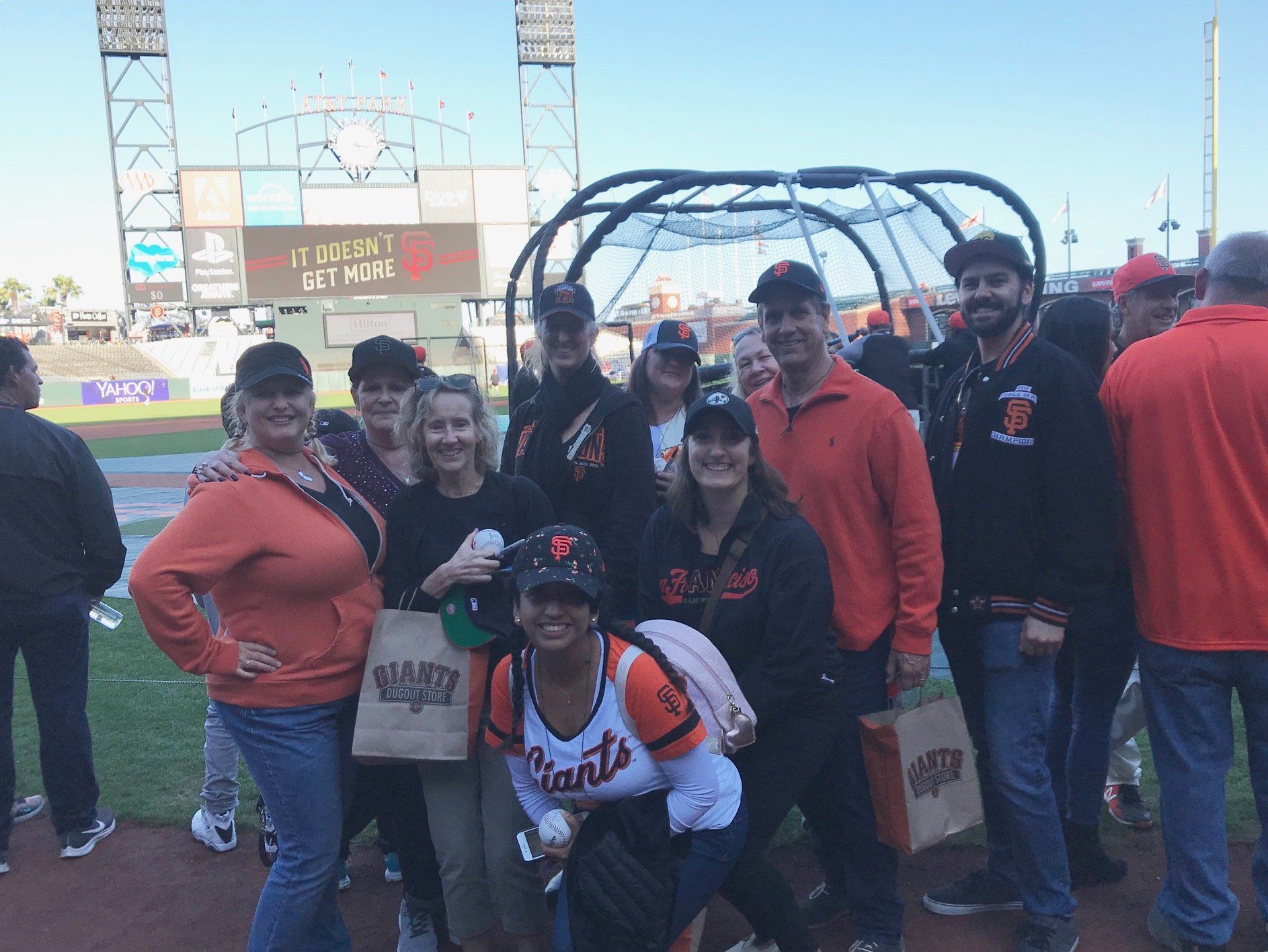 A group of people are posing for a picture on a baseball field.