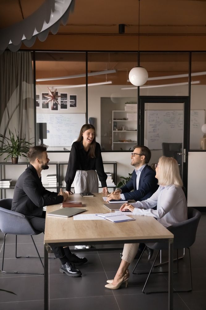 Business team in meeting, discussing documents around a table in a modern office.