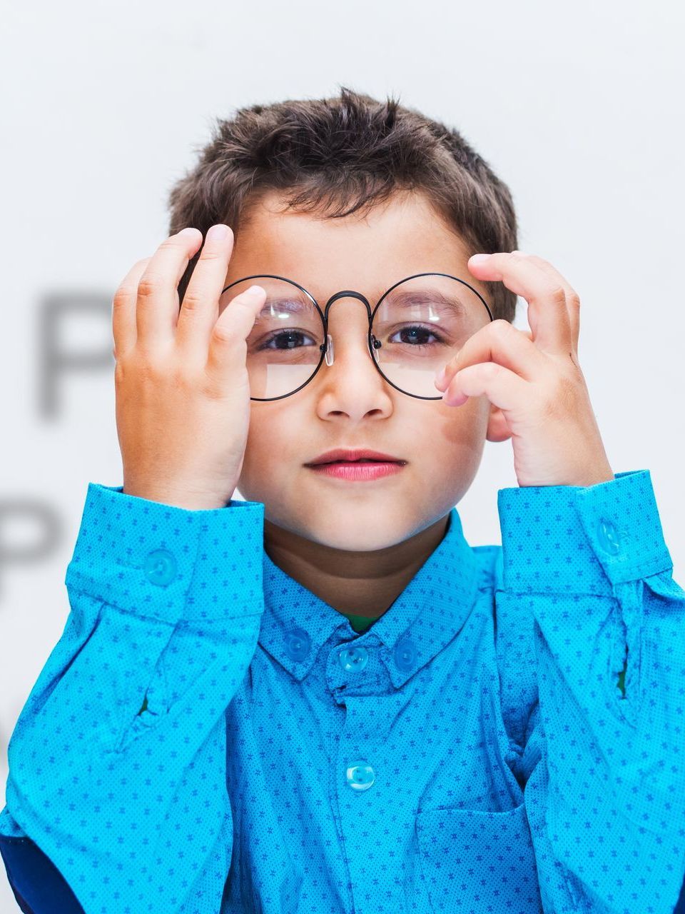 a child putting on glasses from his group vision insurance in san fancisco paid for