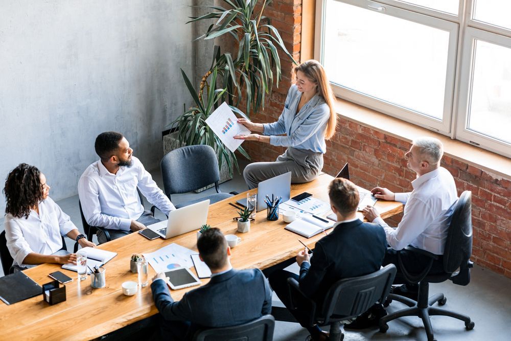 A group of people are sitting around a table having a meeting.