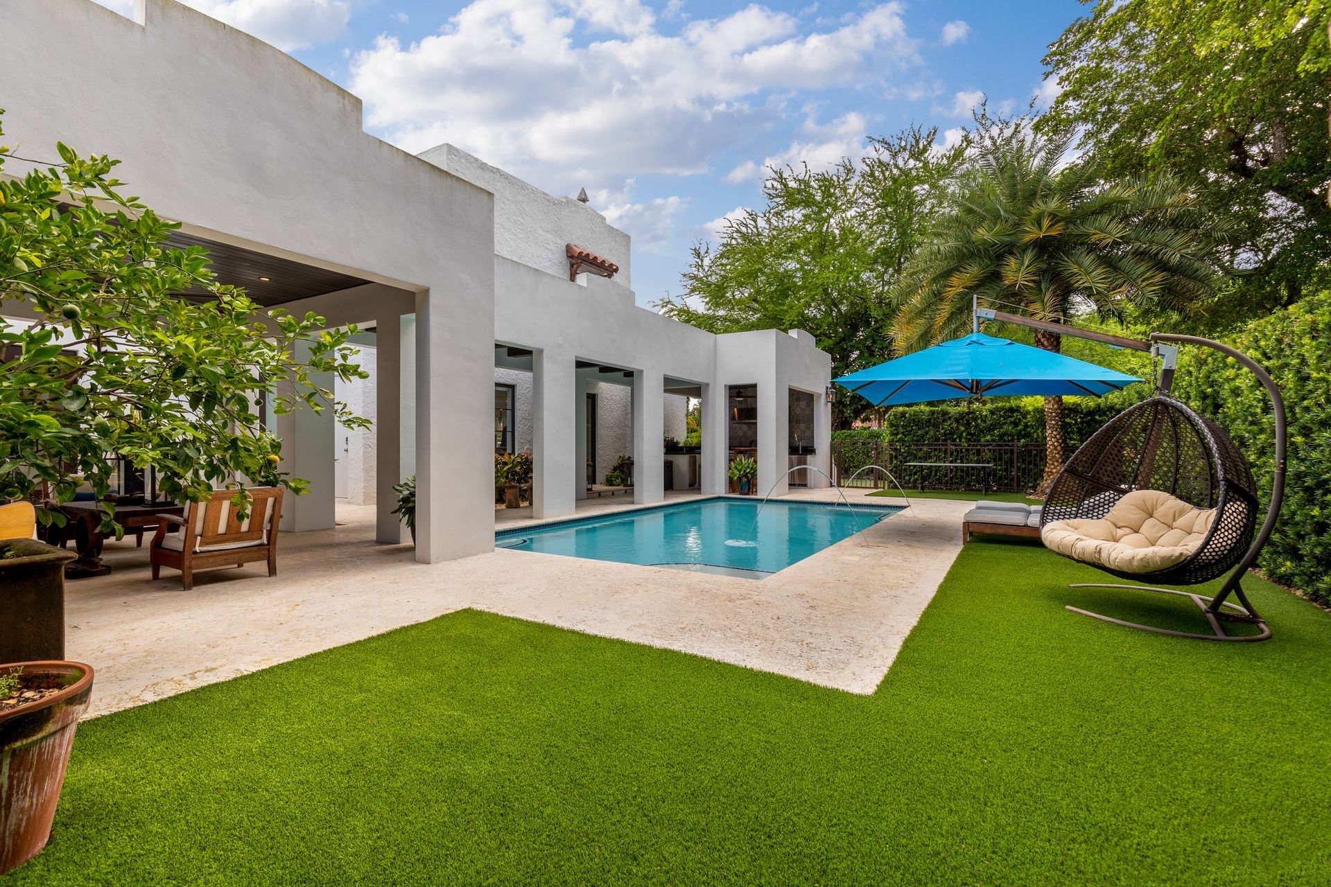 Benefits of installing turf: Modern house with a pool and artificial turf