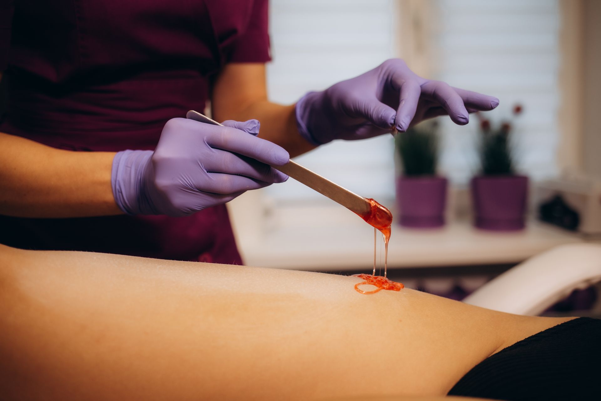 A woman is getting a wax on her leg in a beauty salon.