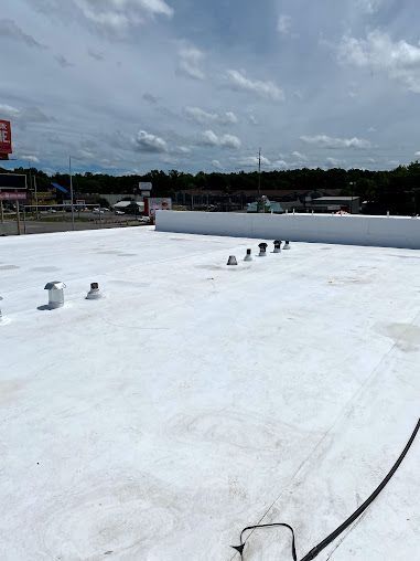A white roof with a lot of vents on it.