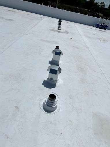 A white roof with a lot of vents on it.