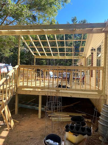 A wooden deck is being built in front of a house.