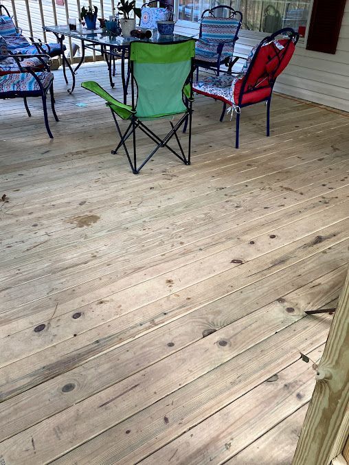 A wooden deck with a table and chairs on it.