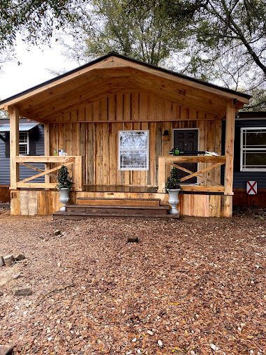 A small wooden house with a porch and stairs.