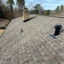A roof with a chimney and a vent on it.