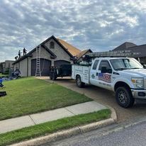A white truck is parked in front of a house.