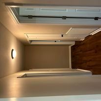 A room with hardwood floors and a light on the wall.