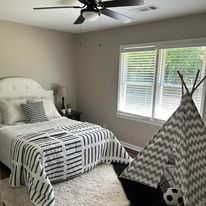 A bedroom with a bed , teepee and ceiling fan.