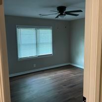 There is a ceiling fan in the room and a window.