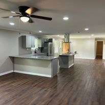 There is a ceiling fan in the kitchen and a ceiling fan in the living room.