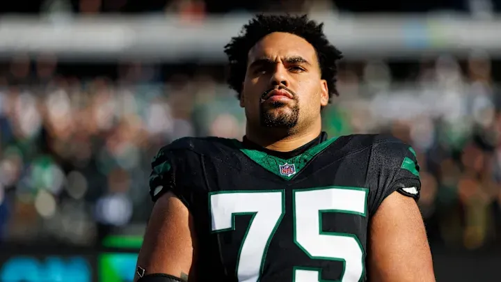 A football player with the number 75 on his jersey is standing on the field.