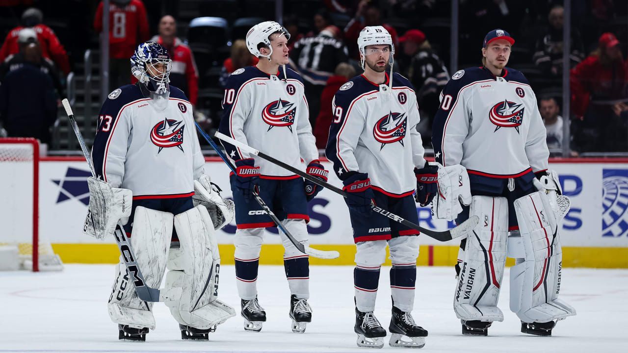 A group of hockey players are standing on the ice.
