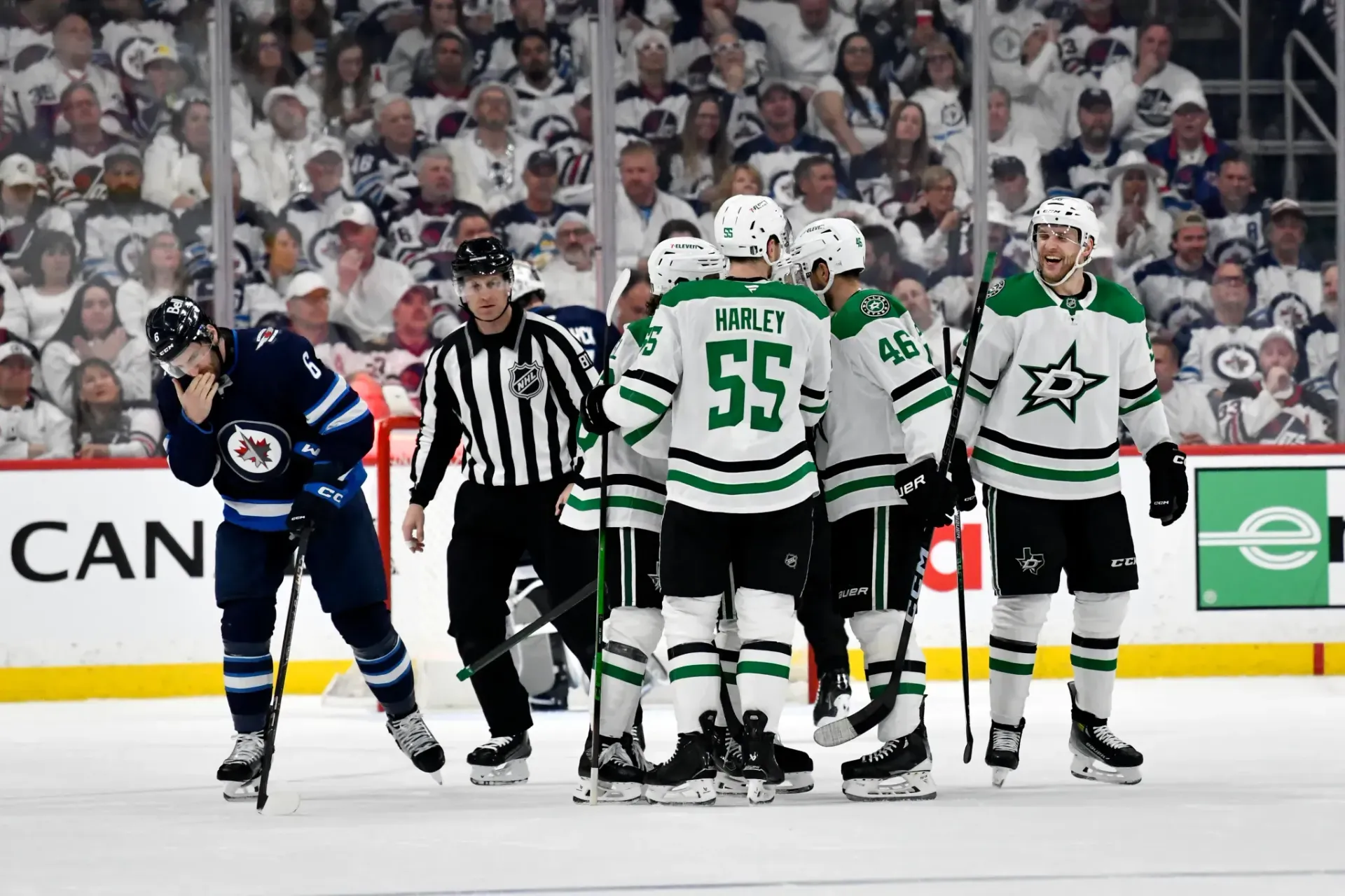 A group of hockey players are huddled together on the ice.