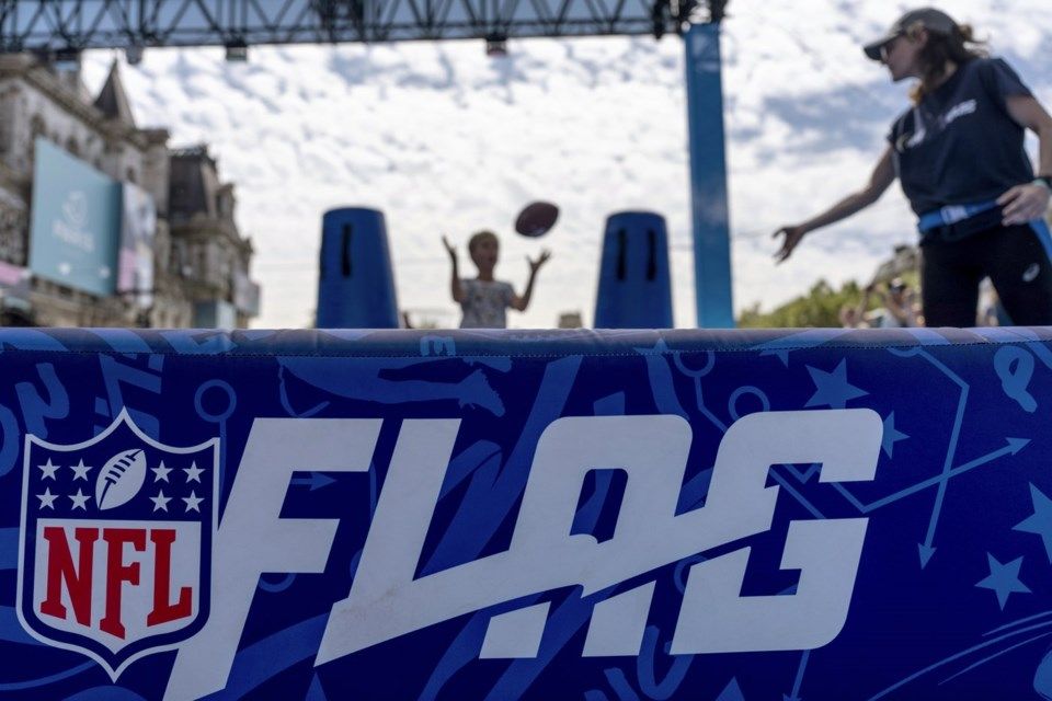 A man throwing a football in front of a sign that says nfl flag
