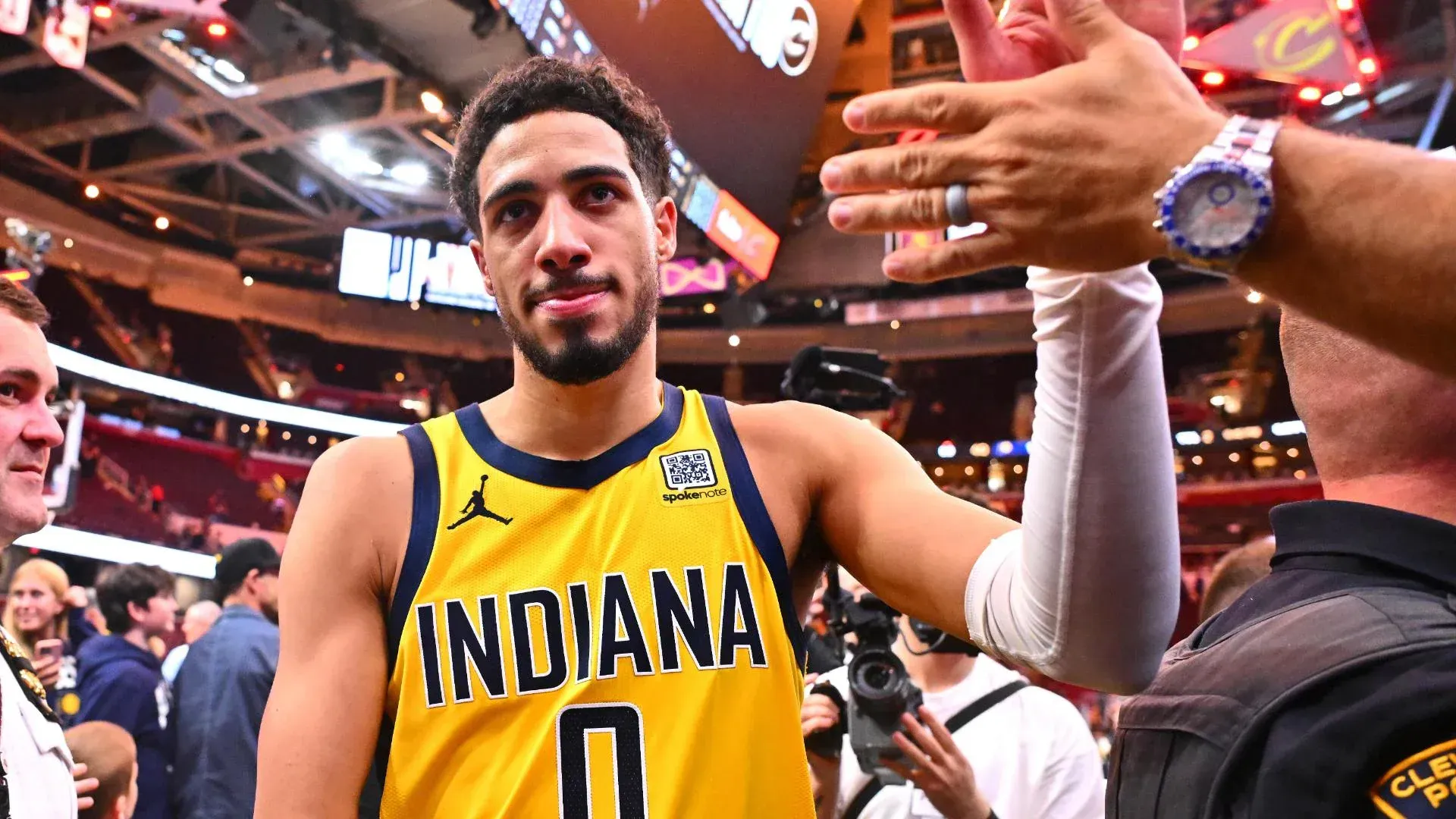 A basketball player wearing a yellow indiana jersey is standing in a stadium.