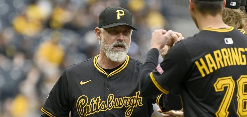 Two pittsburgh pirates baseball players are shaking hands on the field.