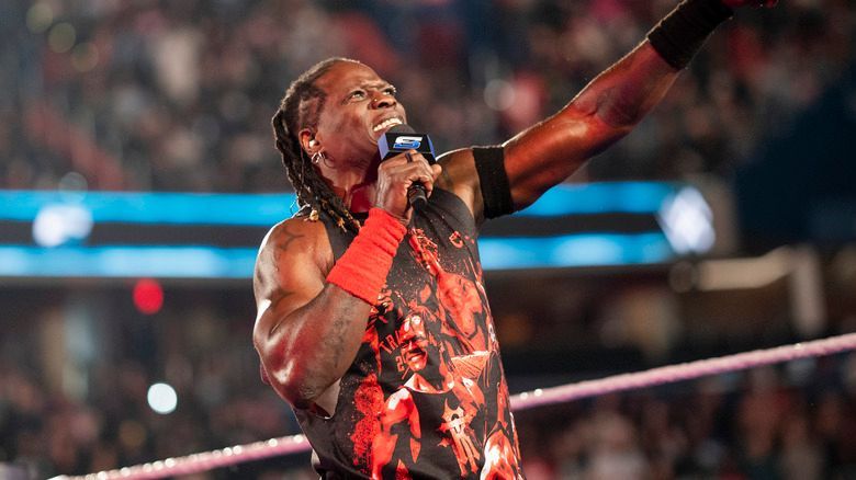 A wrestler is singing into a microphone in a wrestling ring.