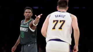 Two basketball players are standing next to each other on a court.