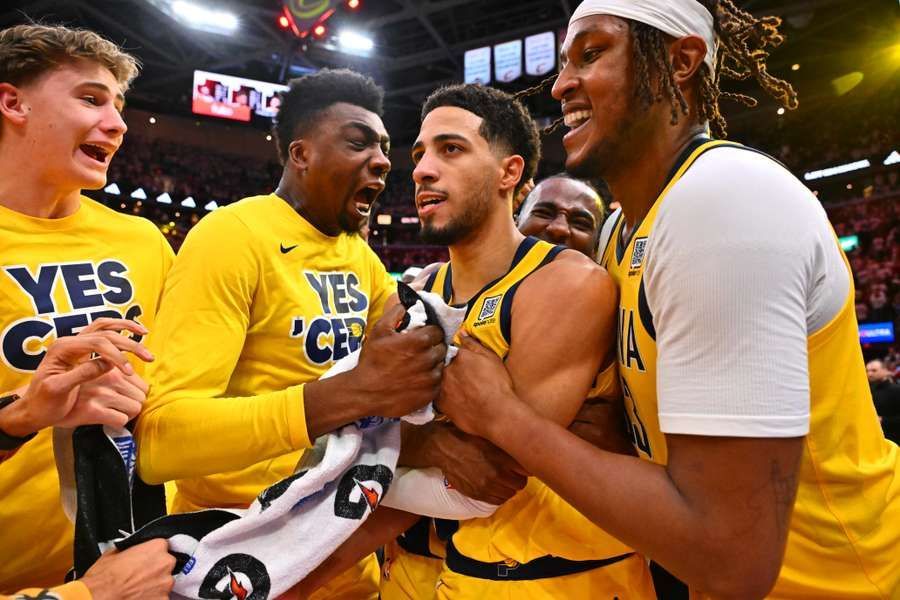 A group of basketball players are hugging each other on a court.